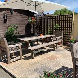 Photograph of our shared patio area with plenty of seating to enjoy our garden.