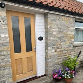 Photograph of the front door of Number 5. One of our self catering studio cottages.